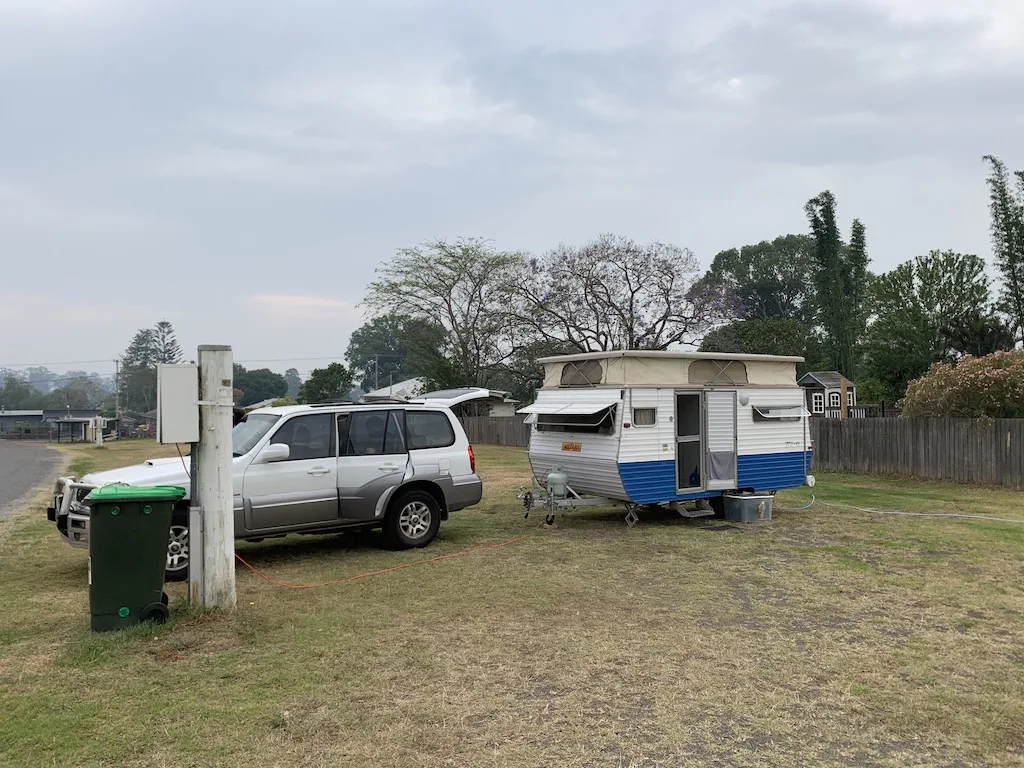 Vintage pop top caravan towed by a white SUV.