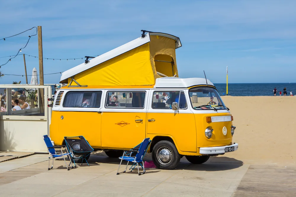 Yellow vintage VW campervan with a pop up roof.