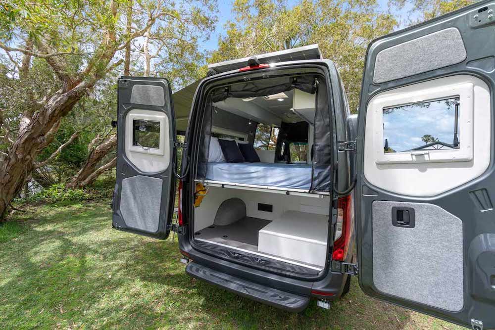 Exterior of the Horizon Motorhomes Boronia campervan with the rear doors open and showing the bed in the rear of the van.