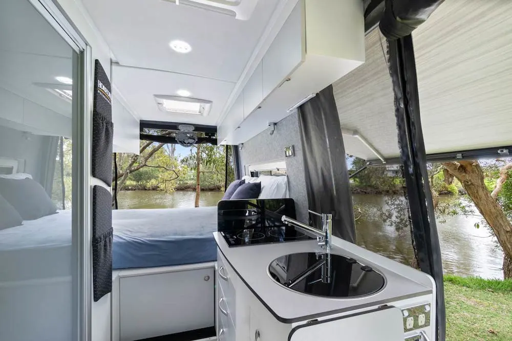 Interior of the Horizon Boronia camper van showing the kitchen area and bed in the background.