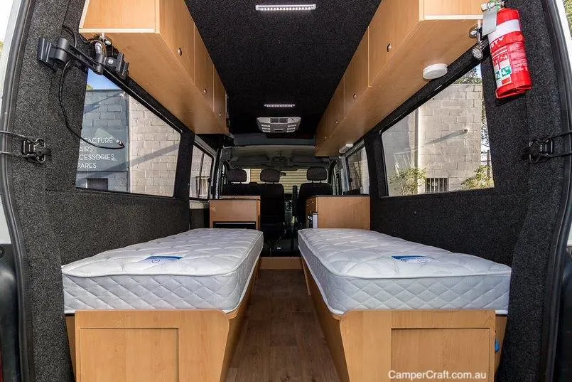 Twin beds in the rear of a converted campervan by van conversion company Camper Craft.
