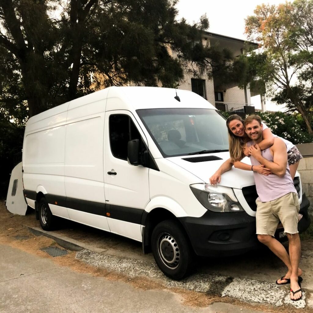 Couple standing in front of a white Mercedes Sprinter van in Austalia.