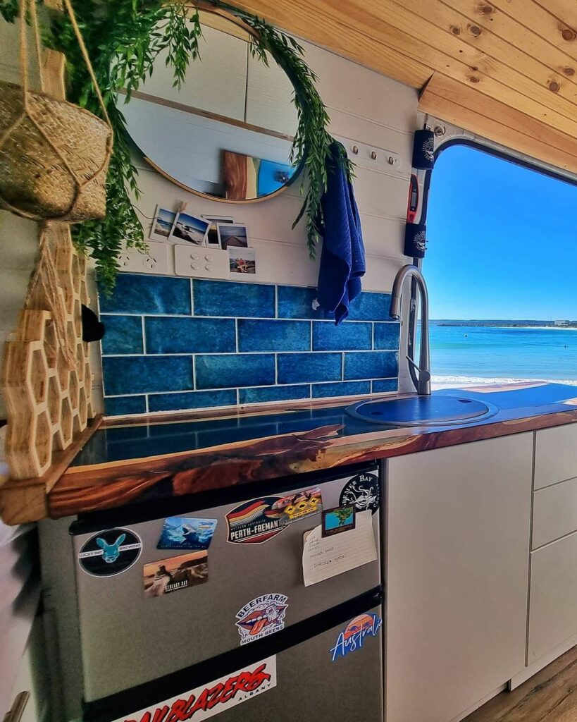 Bright blue splashback tiles in the kitchen area of a converted camper van.