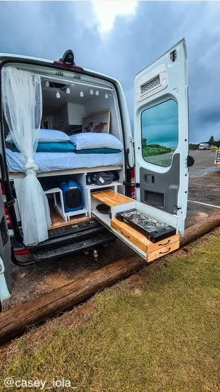 Rear doors of a campervan open with a slide out kitchen.