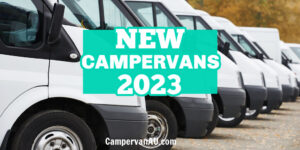 Line of white vans ready for sale, with text: New campervans 2023.