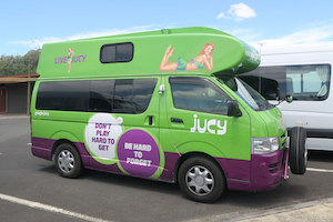 Green and purple Jucy campervan.