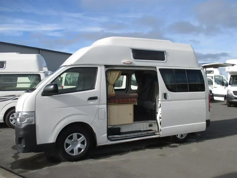 Exterior of a white Talvor Endeavour camper van with the side door open.