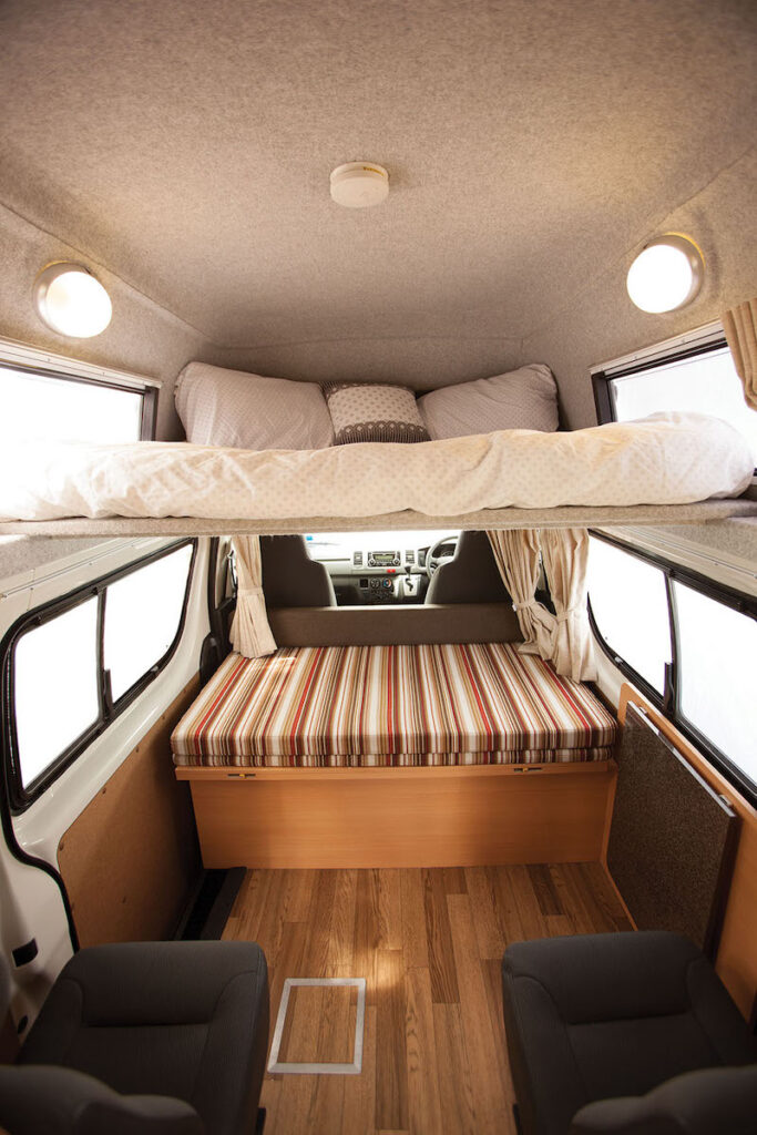 Interior of the Talvor Endeavour motorhome with a loft bed above and seating below.