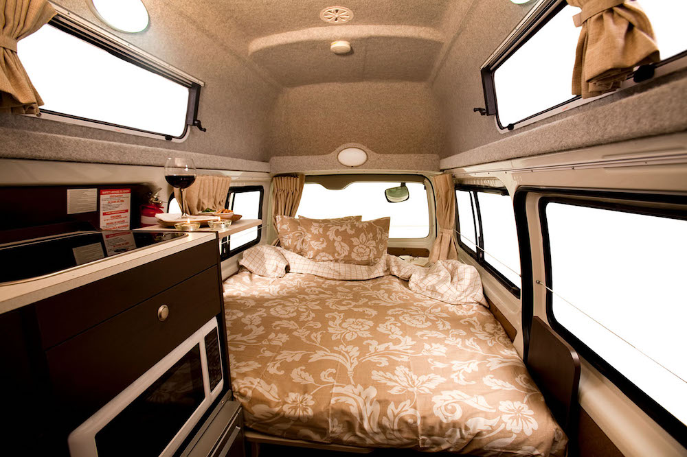 Interior of the Toyota Hiace Talvor Hitop camper van showing the bed in the back.