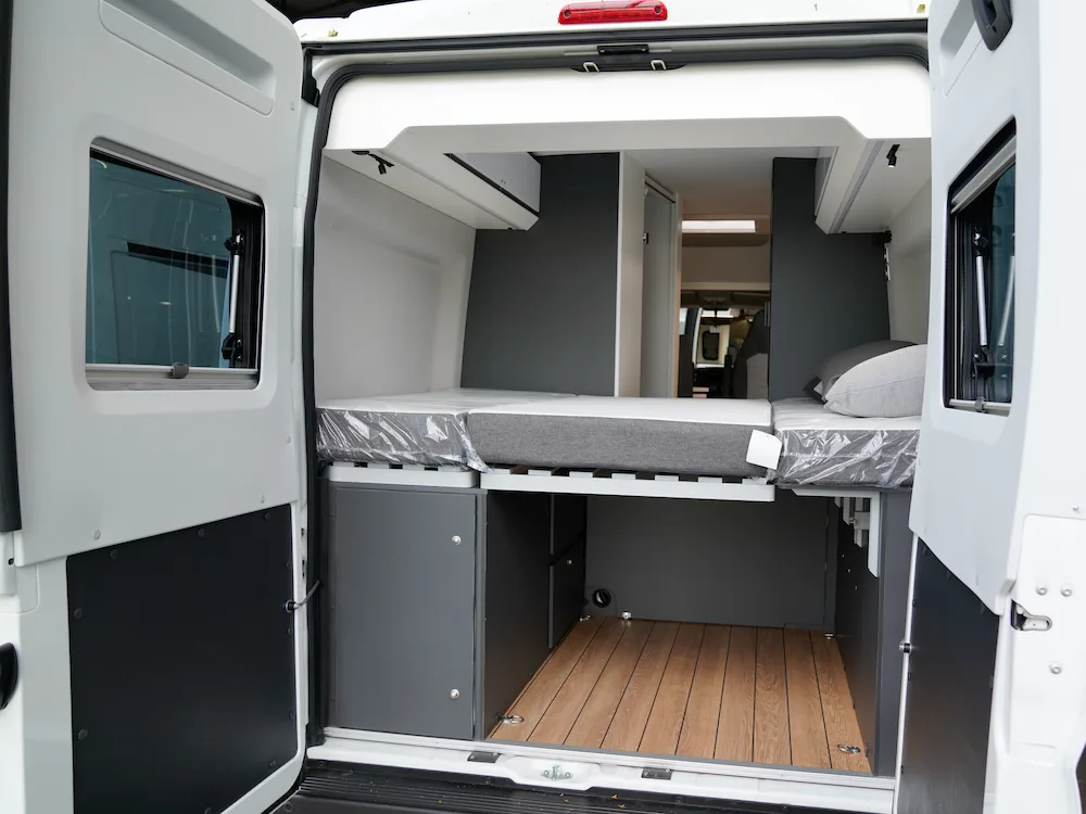Interior of campervan looking in through the rear doors at the bed platform.