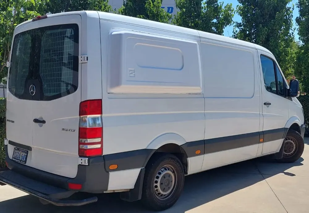 White camper van with body flares on the rear panels.