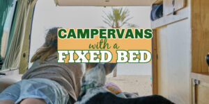 Woman and dog on the bed in a campervan staring out at the view, with text overlay: Campervans with a fixed bed.