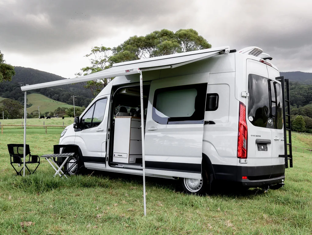 Exterior of the Camplify Luxe Cruiser campervan with the side door open and the awning extended out.
