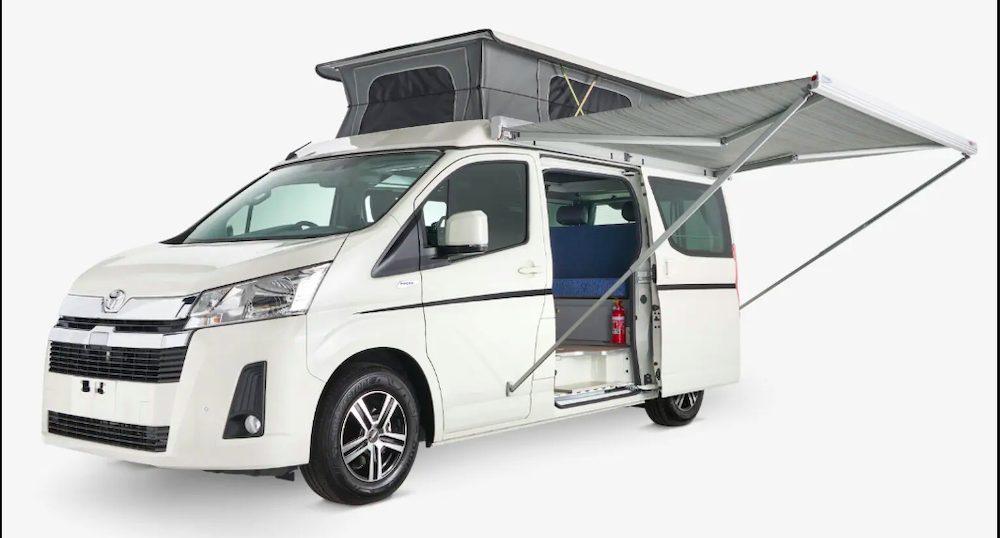 Exterior view of the Frontline Toyota HiAce H30 6 Gen campervan with the pop-top roof up and the awning extended.