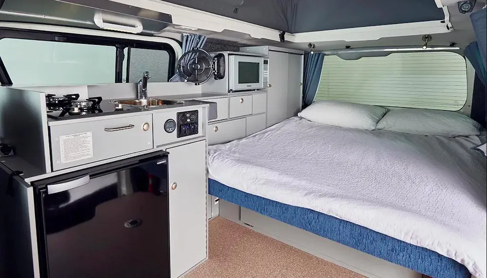 Interior view of the Frontline Toyota HiAce H30 6 Gen showing the bed made up in the back.