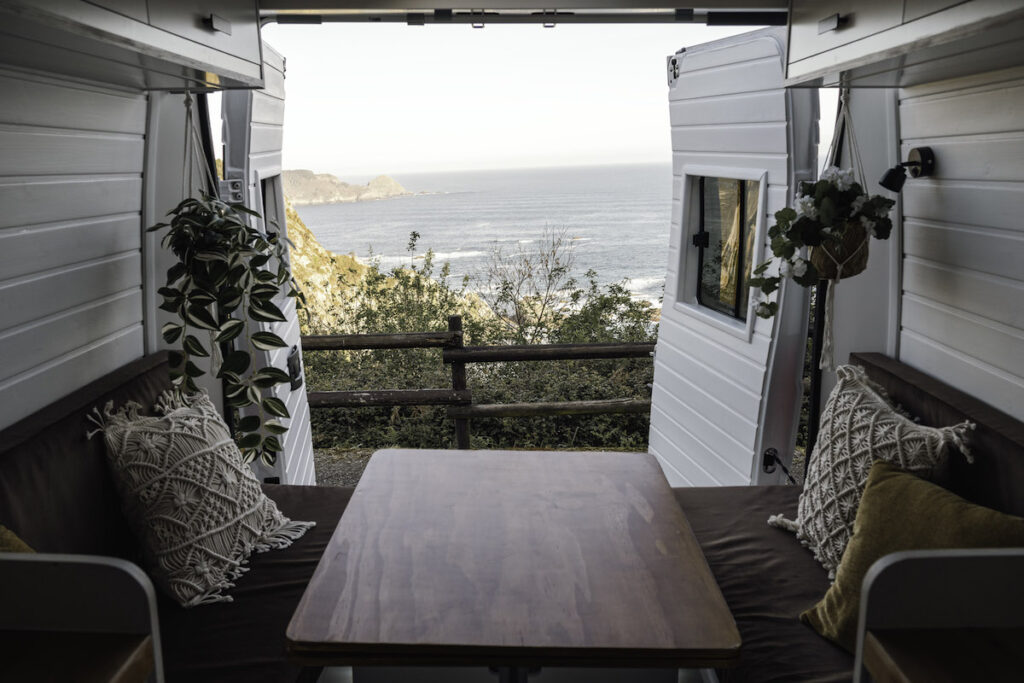 Seating area in a converted van overlooking the sea.