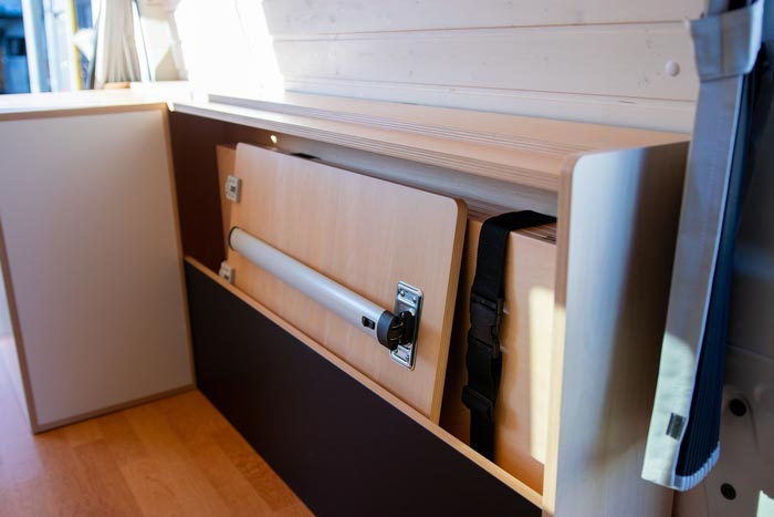 Inside the KumaQ camper van showing the cabinet where the bed and table are stored.
